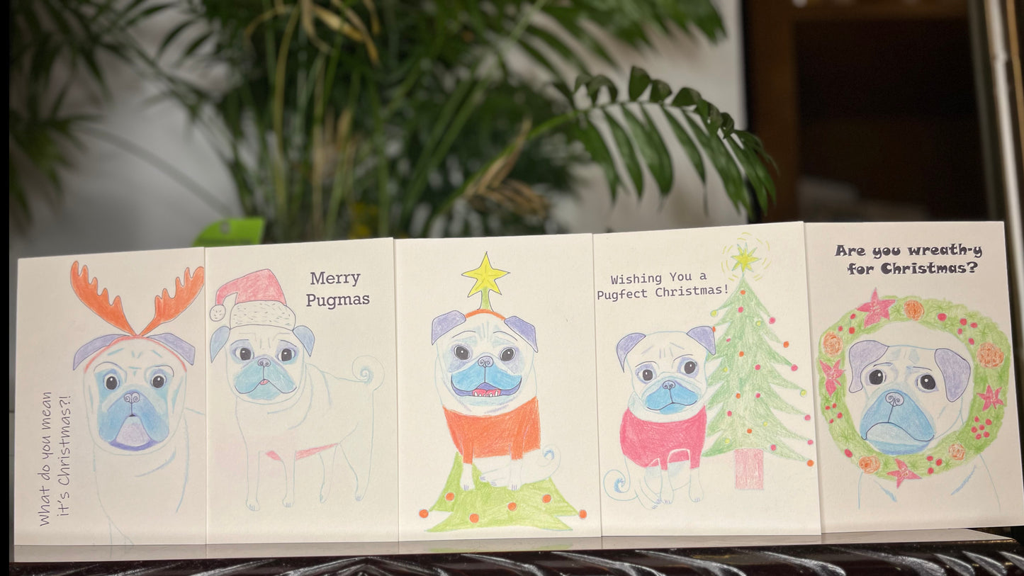 Set of Christmas-themed greeting cards with pug illustrations on a shelf.